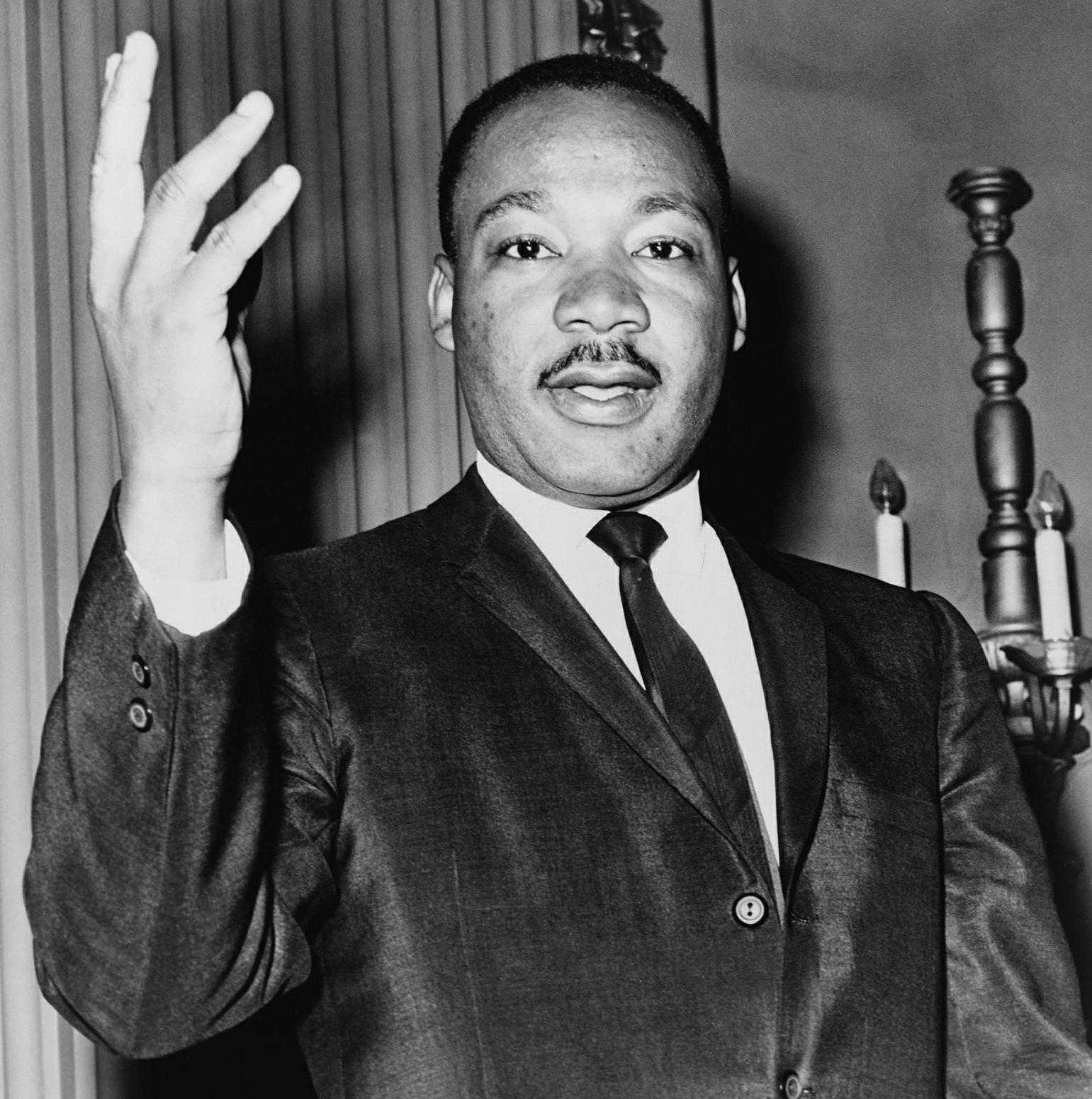 Martin Luther King Jr holding his hand up, black and white picture