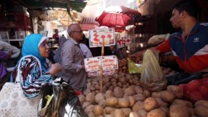 Traditional Giza open market with a potato seller and buyers.